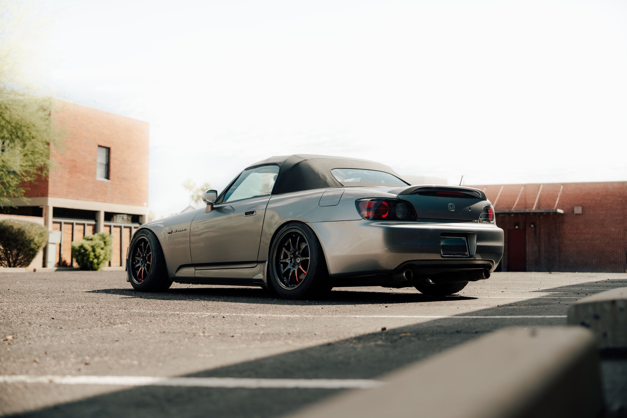Silver Honda S2000 parked in front of a graffiti wall