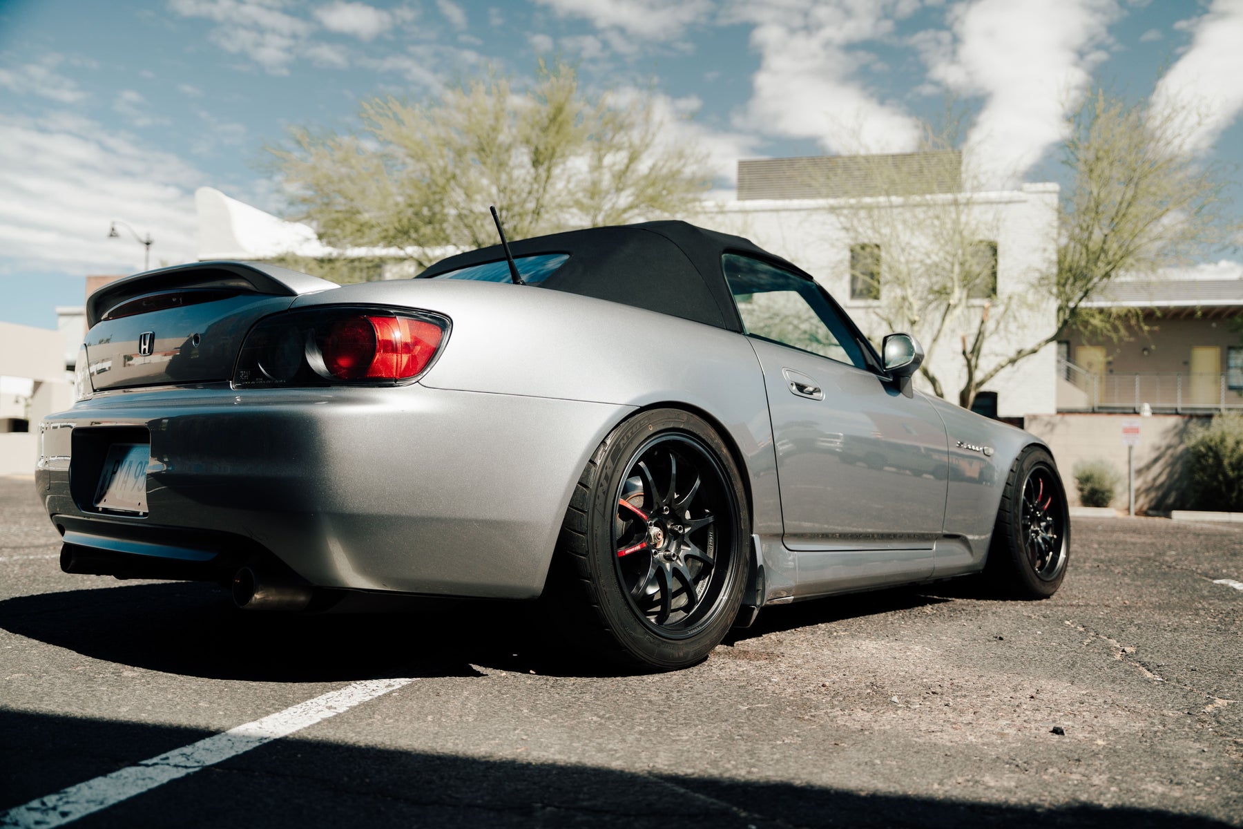 Silver Honda AP1 S2000 parked in front of a mural